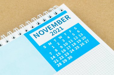 Kahverengi arkaplanda Kasım 2021 masa takvimi.