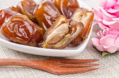 Kurumuş meyveler beyaz kasede ve ahşap çatalda..