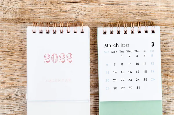 Tahta zemin üzerinde mini Mart 2022 masa takvimi.