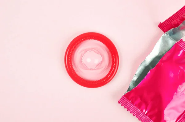 Pink Membuka Kondom Membongkar Pada Latar Belakang Merah Muda Aman — Stok Foto