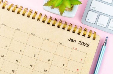 Ocak 2022 Pembe arka planda klavye bilgisayarlı masa takvimi.