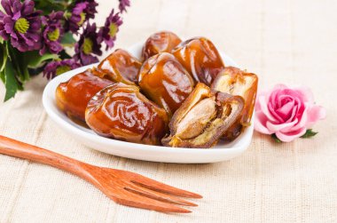 Kurumuş meyveler beyaz kasede ve ahşap çatalda..