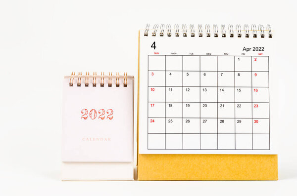 The April 2022 desk calendar on wooden table.