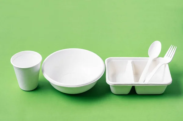 緑の背景に食品や紙ガラスを包装するための環境に優しい生分解性紙 — ストック写真
