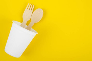 Beyaz renkli kağıt bardakları ve kaşıkları tek kullanımlık. Çevre dostu kavramlar.