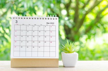 Mart 2022 Doğa arkaplanındaki ahşap masa üzerinde planlama ve hatırlatma için Takvim masası.