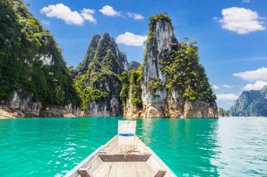 Tayland 'ın geleneksel uzun kuyruklu teknesi Ratchaprapha Barajı veya Khao Sok Ulusal Parkı' nda dağları olan bir gölde, Surat Thani Eyaleti, Tayland