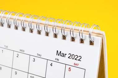 Sarı arkaplandaki Mart 2022 masa takvimini kapat.