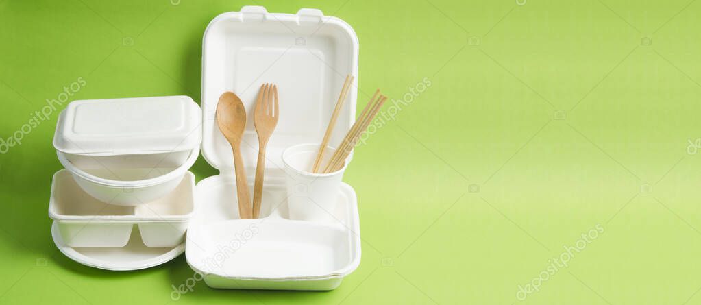 The Eco friendly biodegradable paper disposable for packaging food and paper glass on green background.