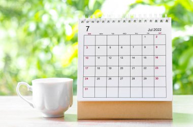 Temmuz 2022 Takvim Masası, organizatörün doğanın arka planındaki ahşap masa üzerinde plan yapması ve hatırlatması için..