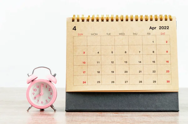 Απρίλιος 2022 Ημερολόγιο Γραφείου Ροζ Ξυπνητήρι Ξύλινο Τραπέζι — Φωτογραφία Αρχείου