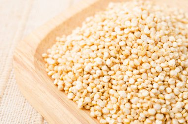 Çiğ, bütün, işlenmemiş kinoa tohumu ahşap diskte. çuval arkaplanı