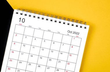 The October 2022 desk calendar on yellow and black background.