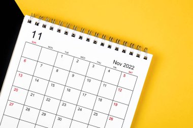 The November 2022 desk calendar on yellow and black background.