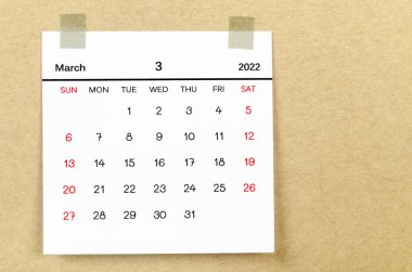 The March 2022 calendar on brown background.