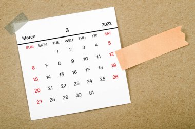 March 2022 calendar with blank adhesive note paper on brown background.