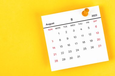 Ağustos 2022 ve sarı zemin üzerinde ahşap pim.