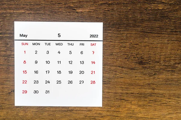 The May 2022 calendar on vintage wooden background.