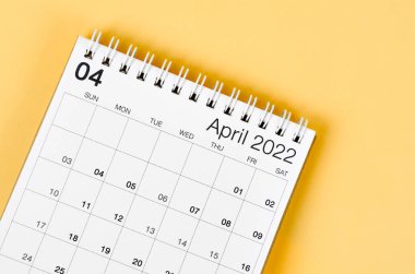 Açık sarı arkaplanda Nisan 2022 masa takvimi.