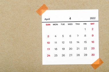 Kahverengi arkaplanda Nisan 2022 takvimi.