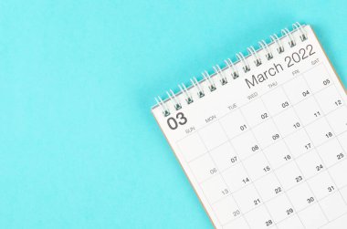 Boş boşluklu mavi arkaplan üzerindeki Mart 2022 masa takvimi.