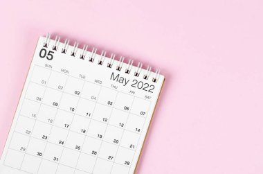 Boş boşluklu pembe arkaplandaki Mayıs 2022 masa takvimi.