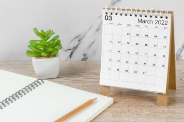 Mart 2022 masa takvimi. Tahta masa üzerinde bitki var..