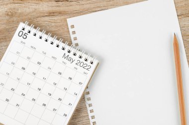 Mayıs 2022 masa takvimi ahşap zemin üzerinde mesajınız veya mesajınız için boş kağıt sayfa ile.