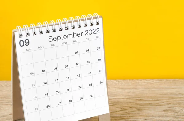 黄色の背景を持つ木製のテーブルの上に2022年9月の机のカレンダー — ストック写真