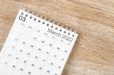 Ahşap zemin üzerinde Mart 2022 masa takvimi.