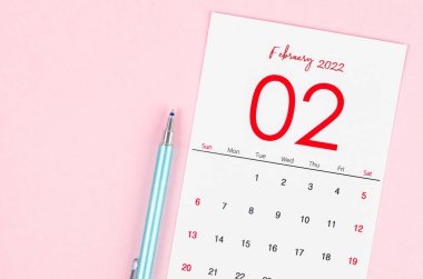 Pembe arka planda kalemli Şubat 2022 takvimi.