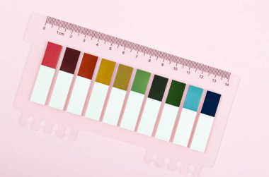 Pembe arkaplanda çok renkli kağıt indeksi seti.