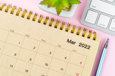 Pembe arka planda klavye bilgisayarlı Mart 2022 masa takvimi.