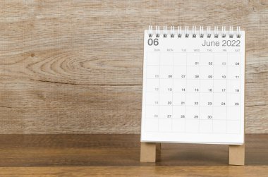 Ahşap zemin üzerinde Haziran 2022 masa takvimi.