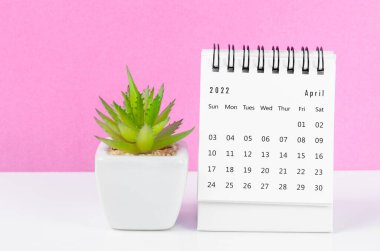 Nisan 2022 masa takvimi. Pembe arka planda saksı var..