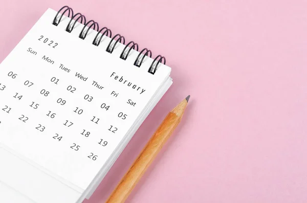 ピンクの背景に木製の鉛筆と2022年2月の机のカレンダー — ストック写真
