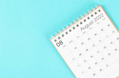 Boş boşluklu mavi arkaplanda Ağustos 2022 masa takvimi.