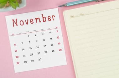 Pembe zemin üzerine not defteriyle Kasım 2022 takvimi.