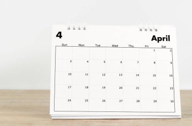 Ahşap zemin üzerinde Nisan 2022 masa takvimi.