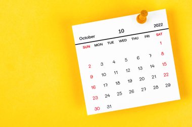 Ekim 2022 takvim ve ahşap pimi sarı arkaplanda.