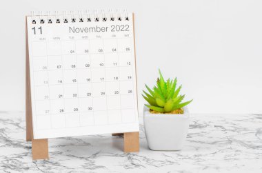 Kasım 2022 masa takvimi mermer masa üzerinde bitki ile.