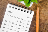 Kalendář psacího stolu z června 2022 s dřevěnou tužkou na dřevěném stole.