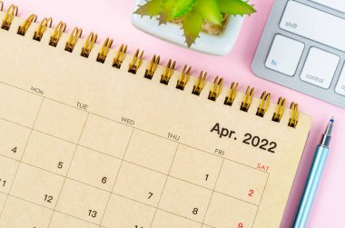 Nisan 2022 Pembe arka planda klavye bilgisayarlı masa takvimi.