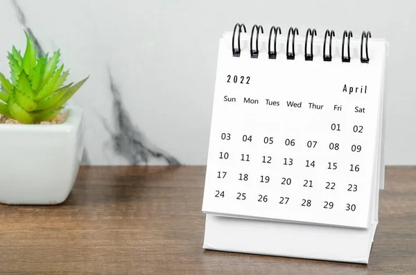 2022年4月木製テーブルの植物鍋付きデスクカレンダー — ストック写真