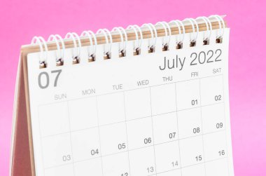 Pembe zemin üzerinde boş boşluklu Temmuz 2022 masa takvimi.