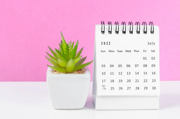 2022年7月ピンクの背景に植物鍋付きデスクカレンダー — ストック写真
