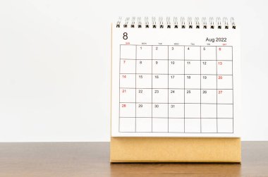 Ağustos 2022 masa takvimi. Tahta masa üzerinde bitki var..