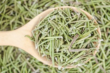 Ahşap kaşıkta kurutulmuş biberiye. Sığ alan derinliğine sahip makro.