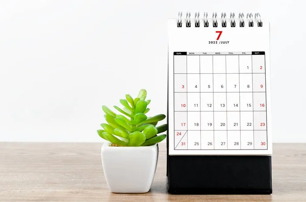2022年7月の机のカレンダー木製のテーブルの植物 — ストック写真