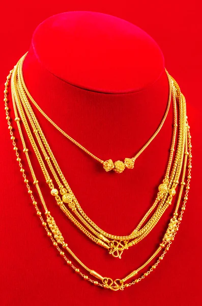 Der Halskettenständer Mit Goldkette Auf Rotem Samtstoff — Stockfoto